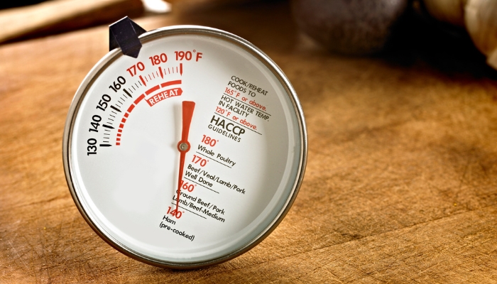 Closeup of a meat thermometer on the table; indicates doneness level for different meats