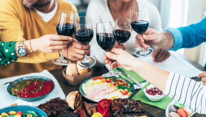 Group of friends celebrating lunch together with cooked meat as the meal