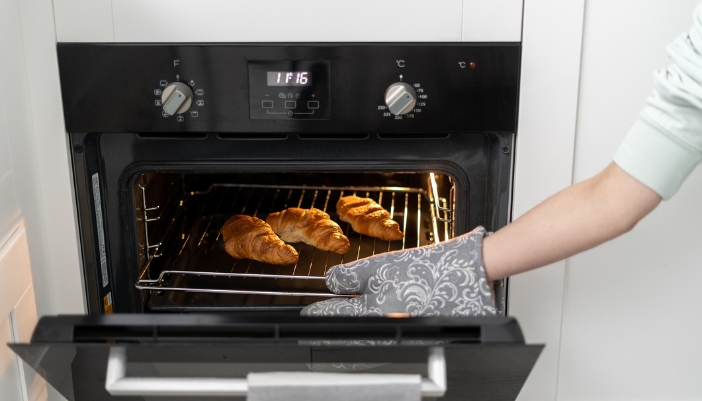 Closeup of croissants baking in an electric wall oven