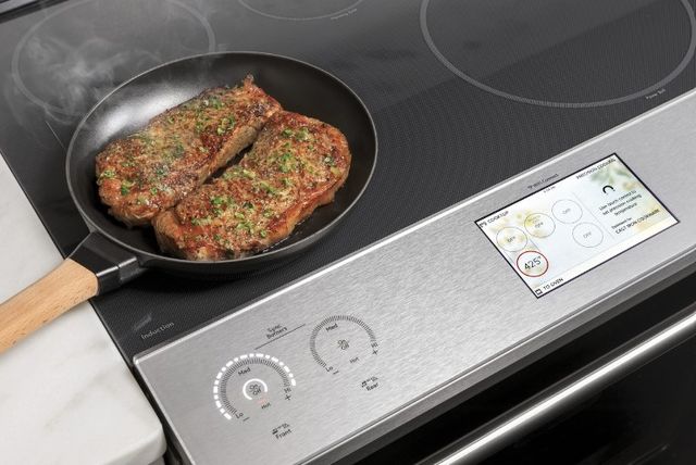 Top view of two steaks cooking on a cafe induction range