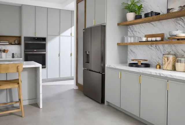 front view of a counter depth refrigerator in a white kitchen with gold accents