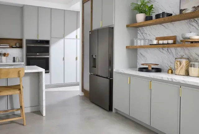 angled view of a white kitchen with a dark grey counter depth refrigerator