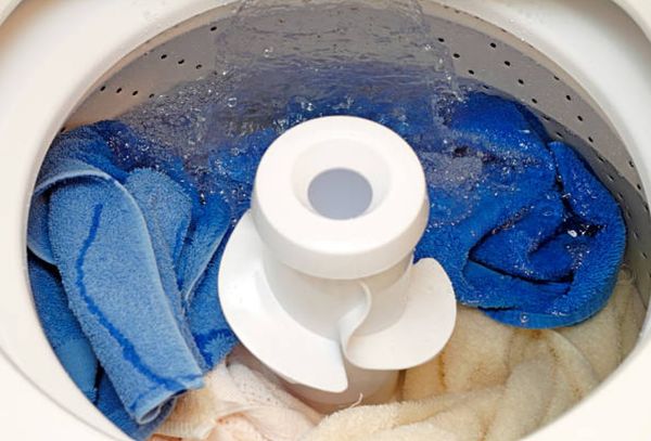 Credit:Serenethos. top-load washing machine full of towels getting filled with water