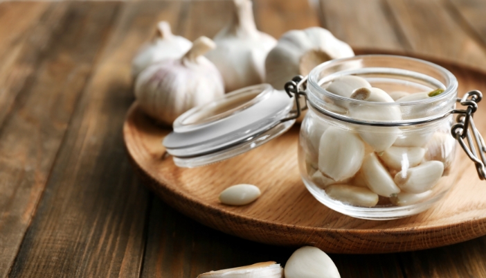 A jar filled with peeled garlic cloves