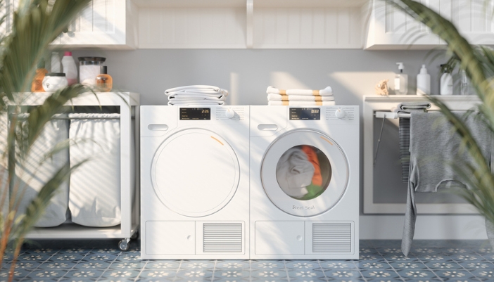 A bright, white laundry room with white laundry appliances and plants.