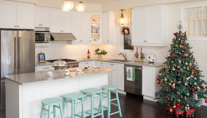 A family’s kitchen decorated for the holidays with a tree and other accents.