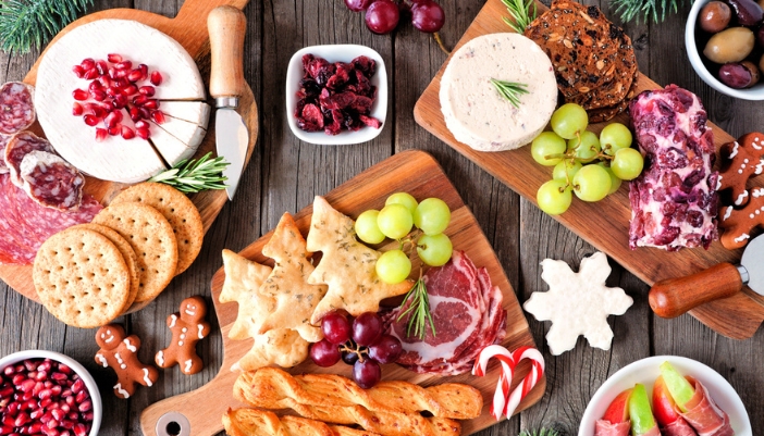 A table spread of holiday appetizers – including fruit, cheese, and pastries.
