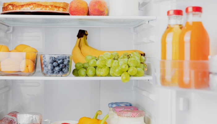 An open organized fridge with each category of food in it’s own place.
