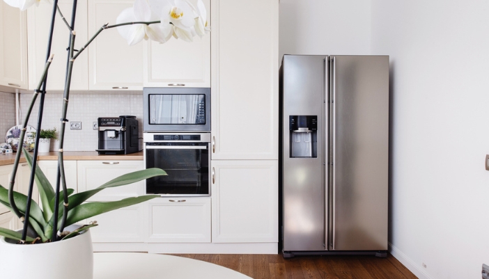 A stainless steel fridge in an empty modern kitchen