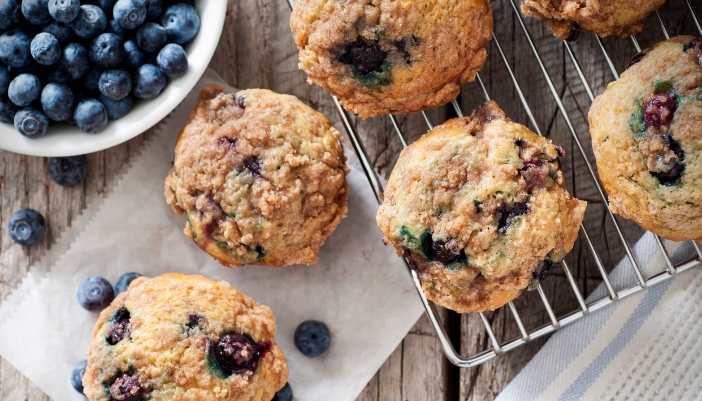 Blueberry muffins cool on a rack.