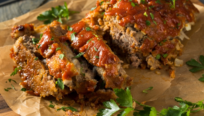 A sliced loaf of meatloaf on parchment paper.