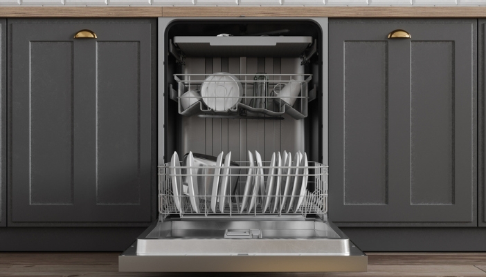 An open, fully loaded dishwasher in a modern kitchen with gray cabinets.