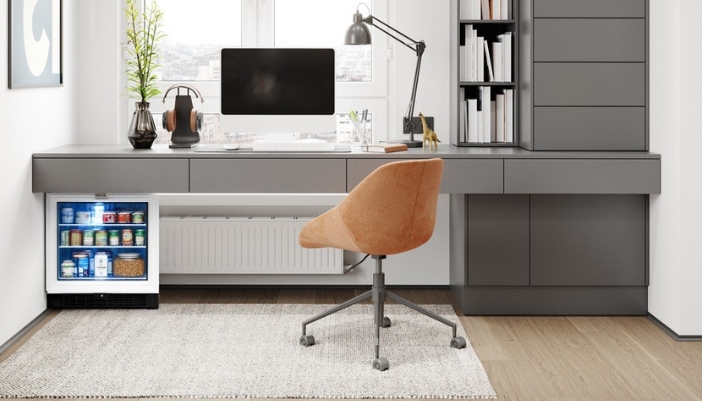  A home office with a mini fridge under the desk.