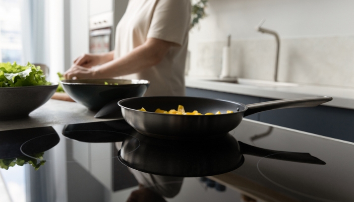 A woman cooks in her kitchen on an induction range.