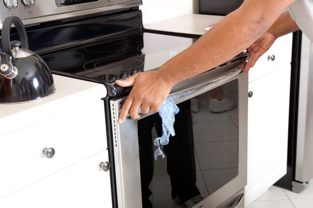close view of a person completing the installation of a range in a modern kitchen