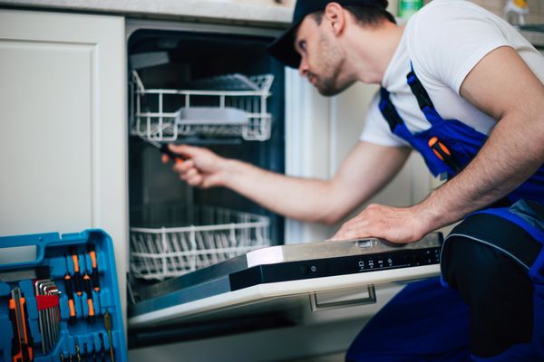A repair technician fixing a dishwasher 