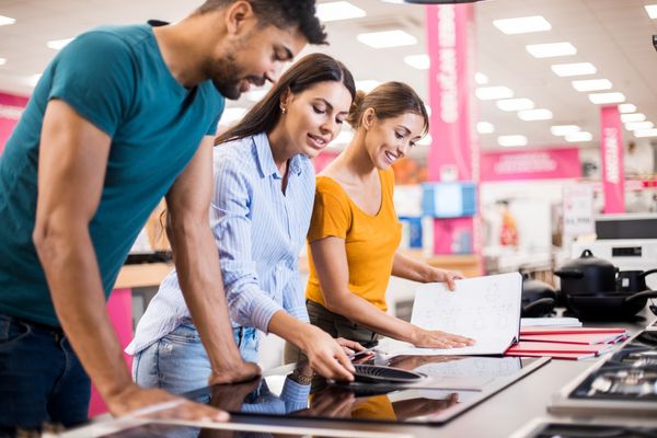 shoppers review a smooth top cooktop in a store 