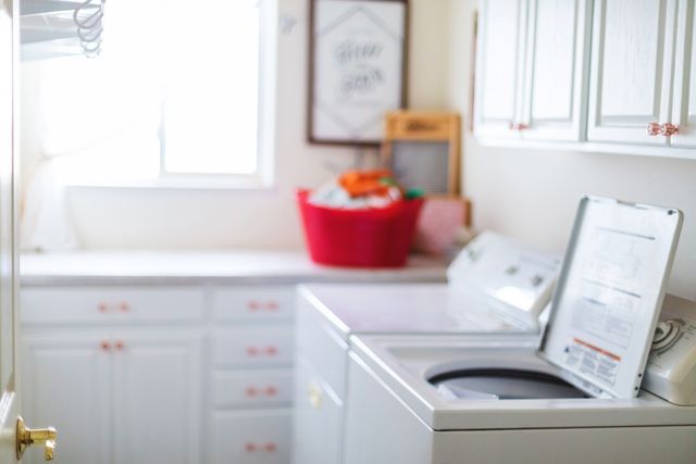 view of an opened top load washing machine in a modern laundry room