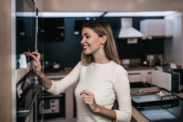 A smiling woman shopping for an oven 