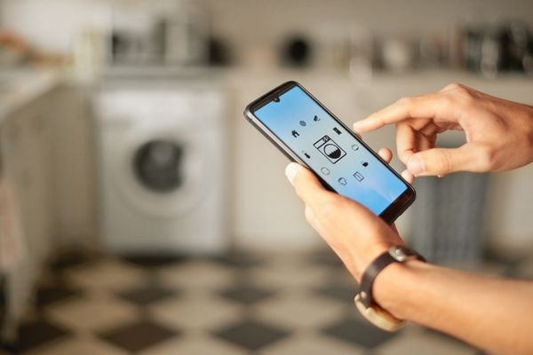 A person using a smart phone AI washer feature 