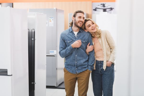 A smiling man and woman exploring appliances in a store
