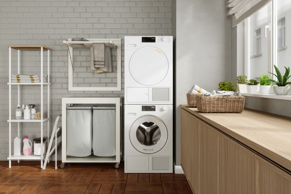 A white stacked washer dryer in laundry room