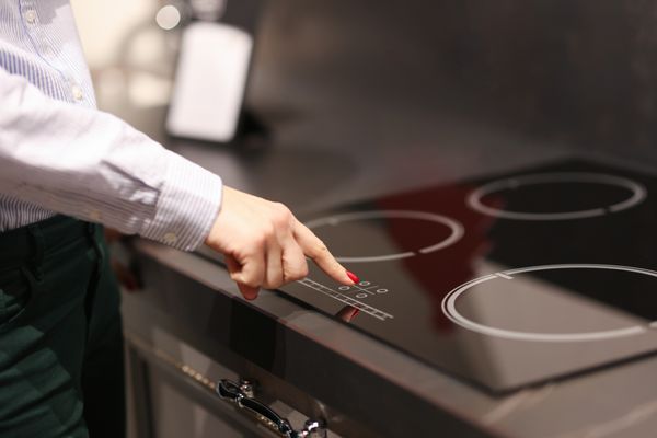 A woman testing a glass cooktop 