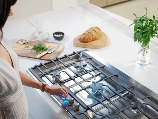 A woman using the Thermador SGSXP365TS gas cooktop 