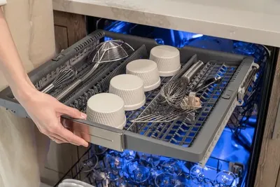 A person pulling out the Thermador Star Sapphire DWHD661EFP dishwasher rack 