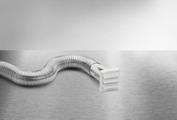 A tin dryer hose with attachment on a metal surface 