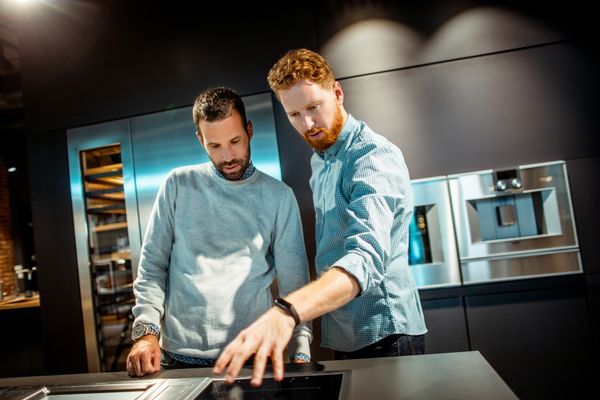 Two men reviewing appliances in a store