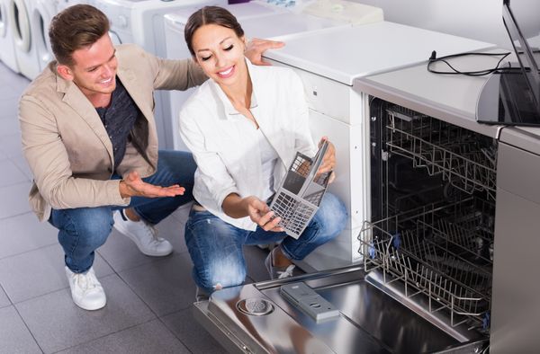 iStock Credit: JackF A man and a woman inspecting a dishwasher silverware caddy