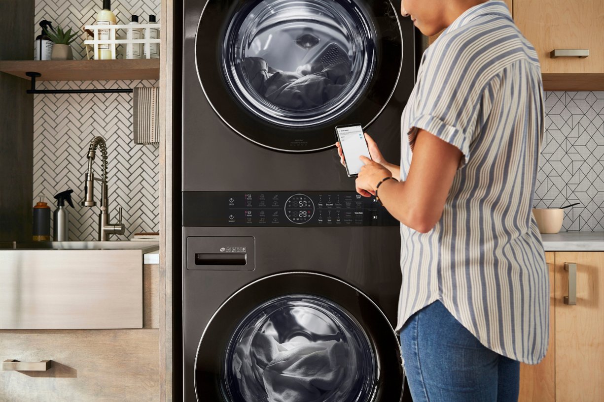 woman remotely starting smart washer and dryer