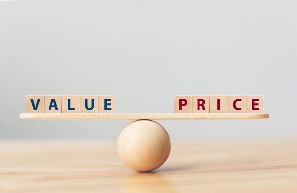 A wooden ball balancing wooden tiles spelling value and price 