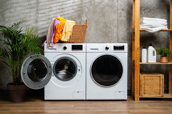 A front load washer and dryer in a laundry room with a basket 
