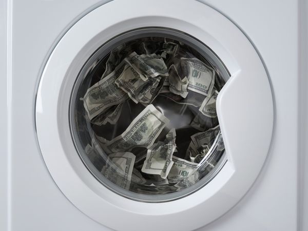 Front view of a front load washer full of $100 bills 
