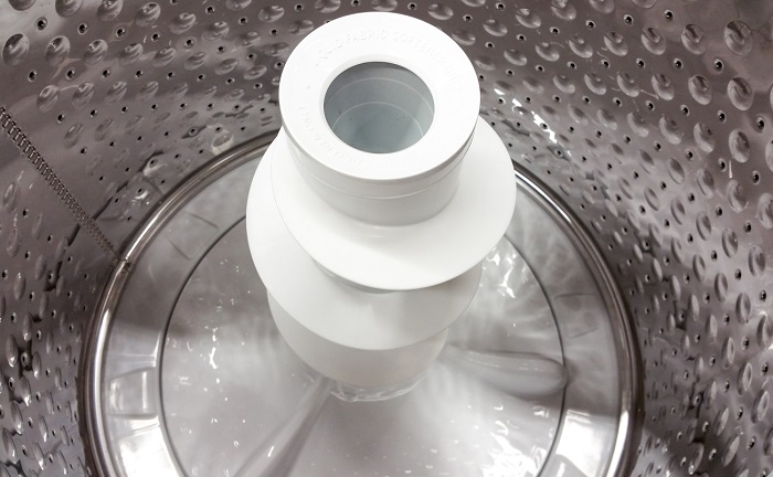 Top view of agitator washer empty with a shiny metal wash basket.