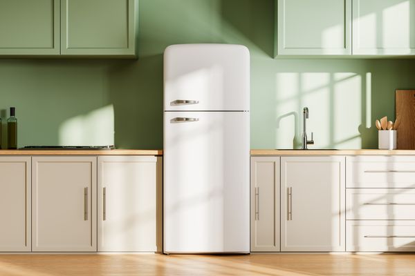 A white retro refrigerator in a green kitchen