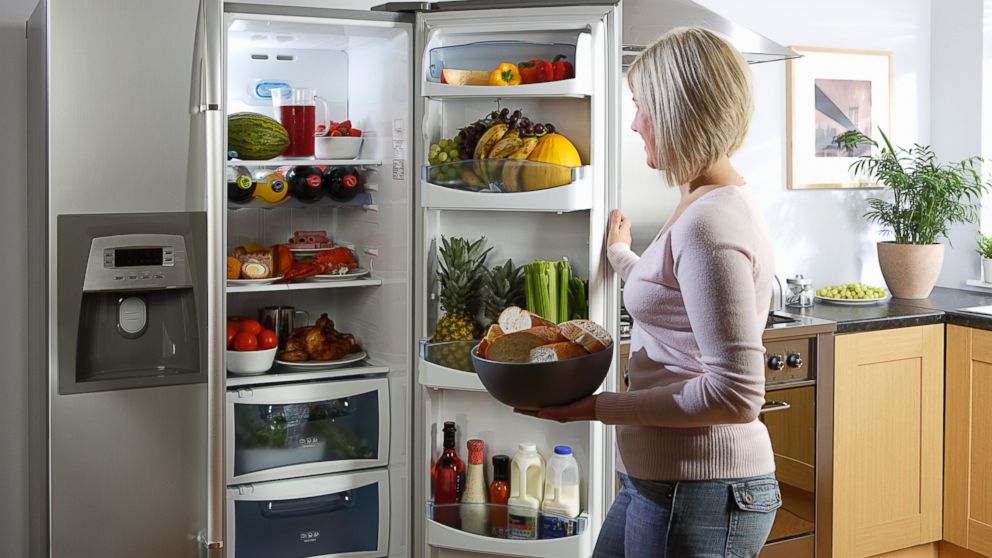 Woman Opening Fridge in Kitchen