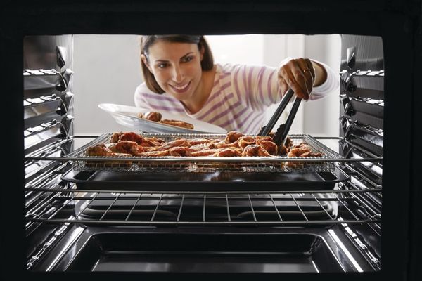front view of a woman Cooking Food in Air Fry Oven