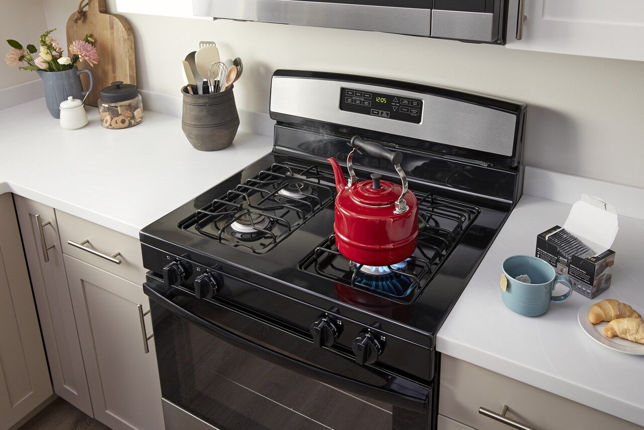 Gas range with red kettle on it