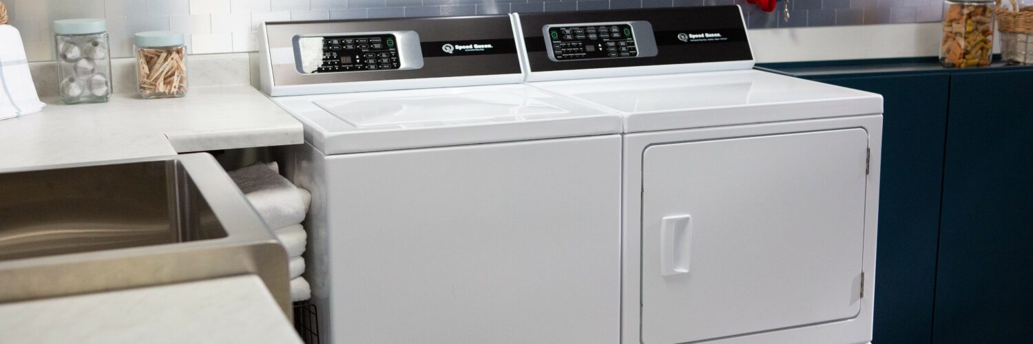 Shot of a Speed Queen top load washer and dryer set in a laundry room 