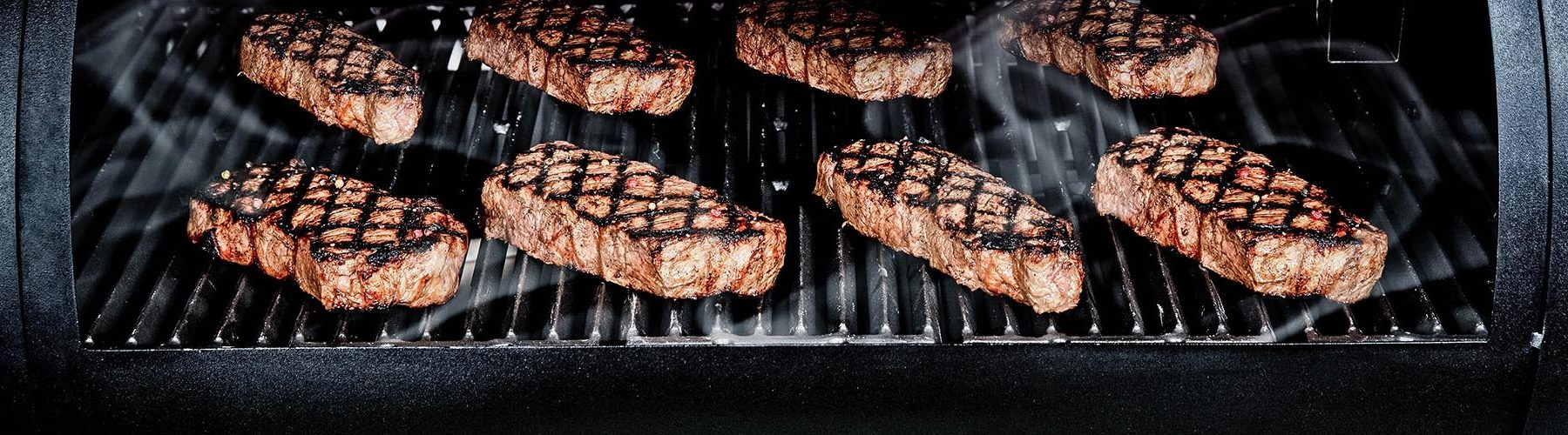 Steaks grilling on a pellet grill 