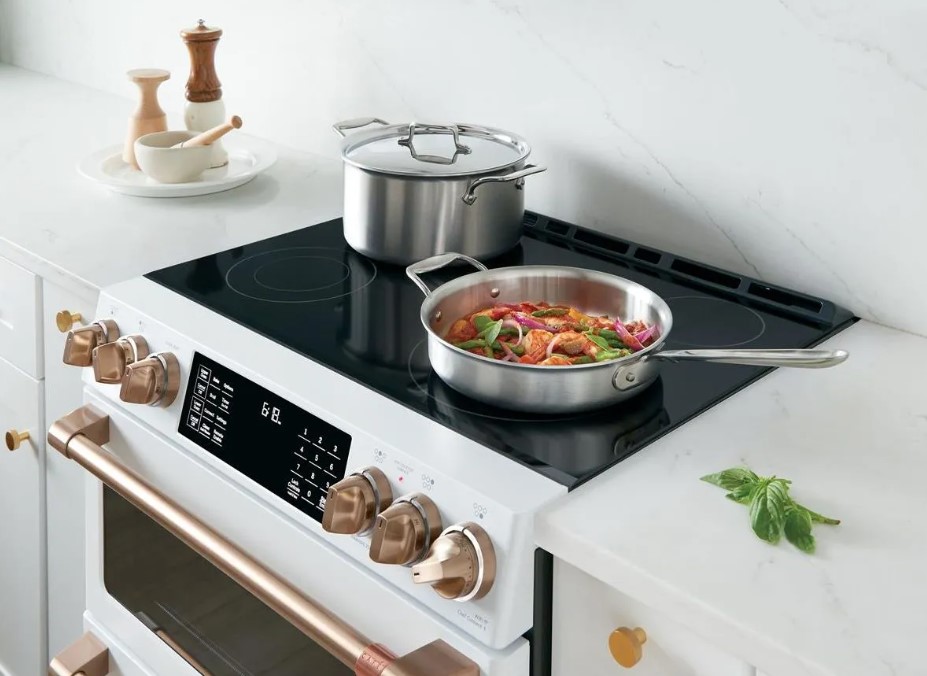 A Cafe electric range with a pot cooking vegetables 