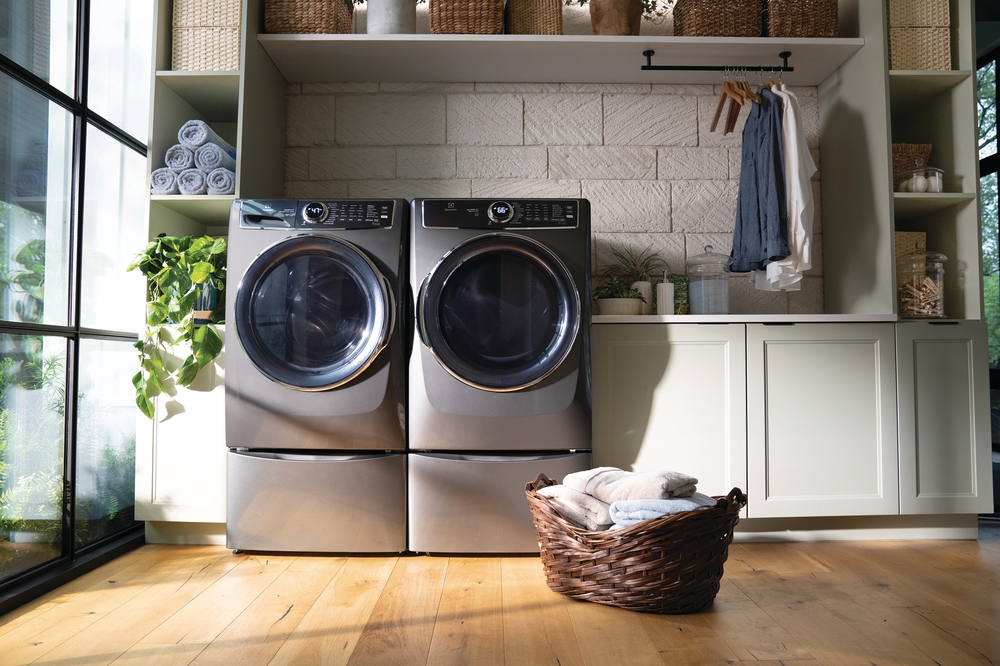 A pair of front loading laundry machines in a well lit laundry room