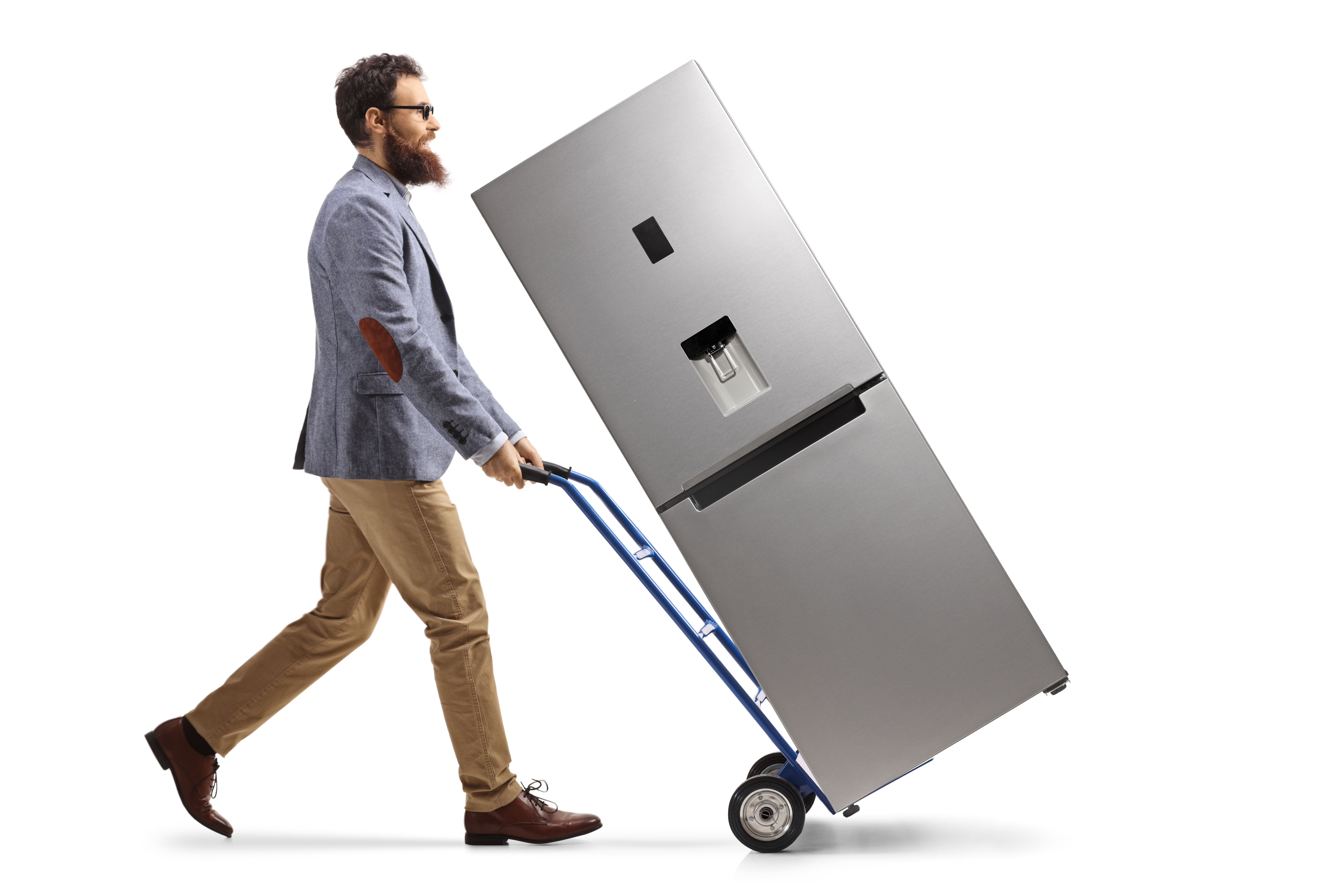 Man in a suit hauling a refrigerator on a dolly 