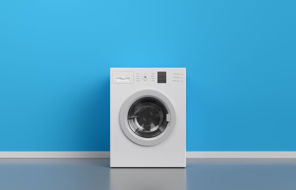 A front load washing machine against a blue wall