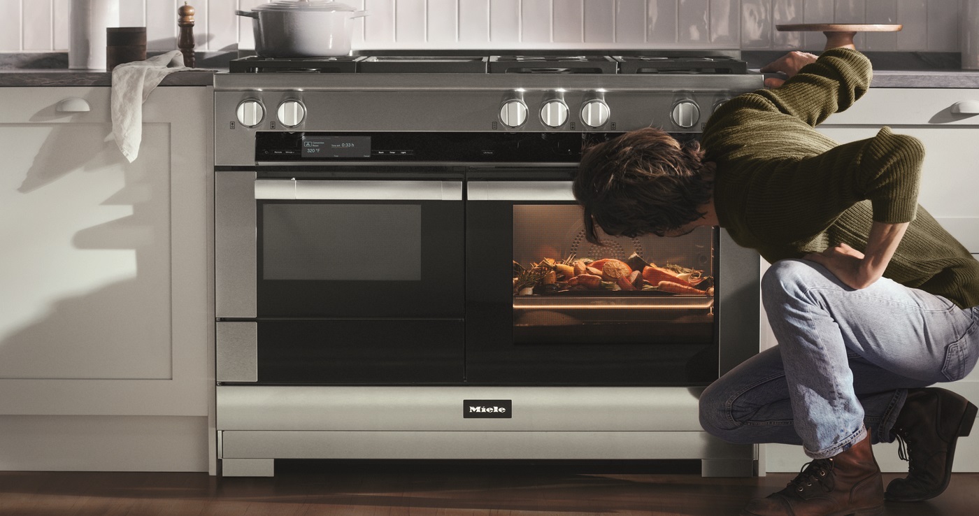 Man looking into a Miele 48” dual fuel range 