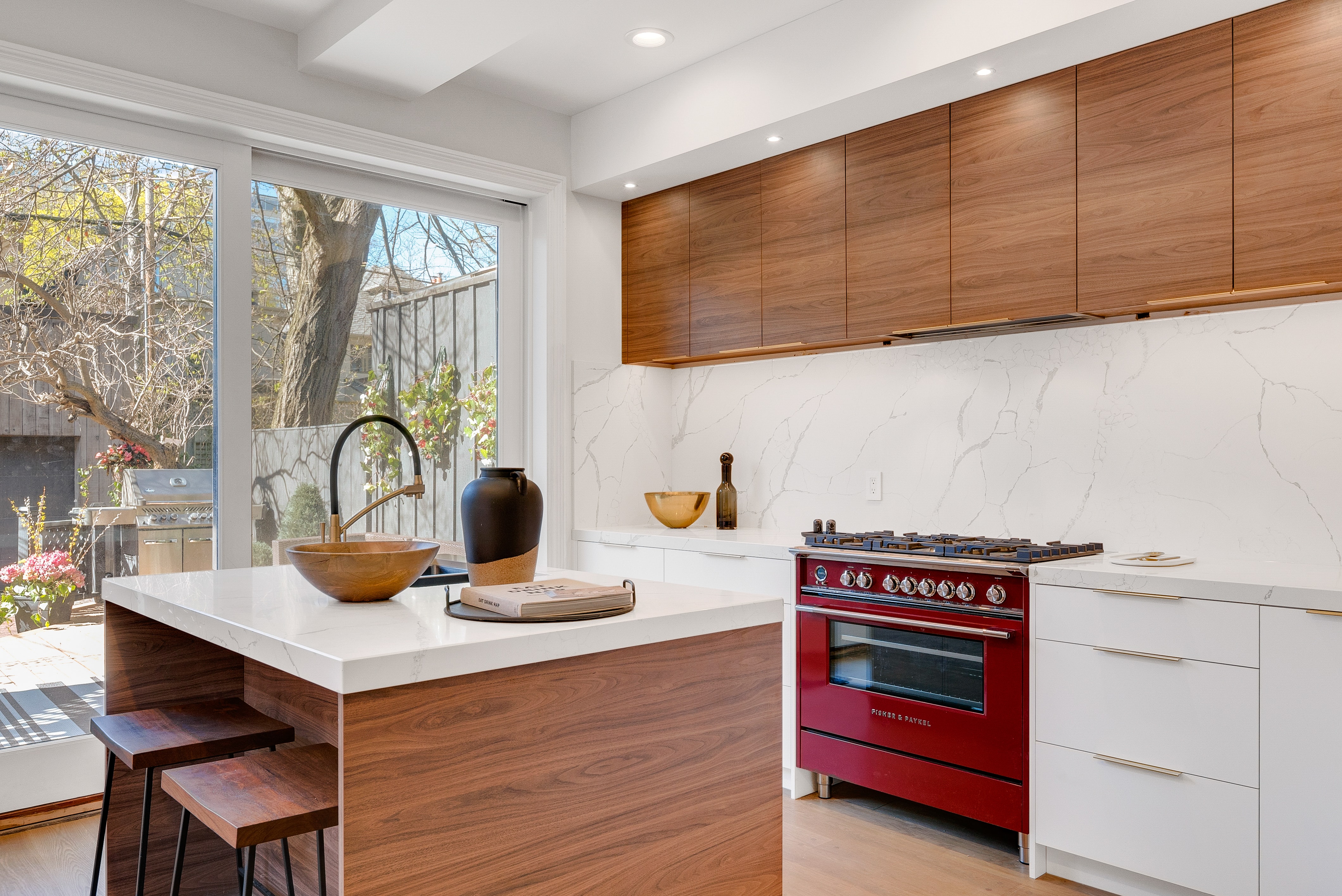 Red range in a kitchen with brown cabinets