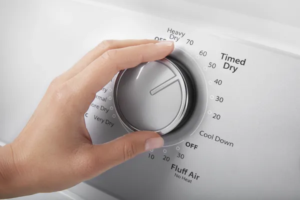 A person selecting a dryer setting on the Whirlpool WGD4950HW dryer 